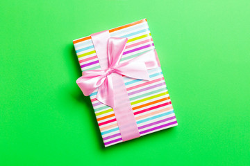 Top view Christmas present box with pink bow on green background with copy space