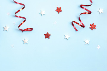 New Year and Christmas composition. Frame frome red and white christmas toys on blue background. Top view, flat lay, copy space