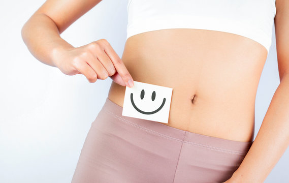 Women Stomach Health. Healthy Female With Beautiful Fit Slim Body  Holding White Card With Happy .Smiley Face In Hands Good Digestion Concepts. High Resolution
