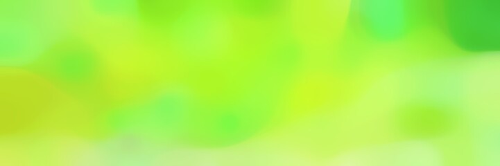 blurred horizontal background with green yellow, pale green and moderate green colors and space for text