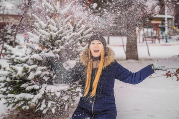 Young woman enjoys a winter snowy day in a snowy forest