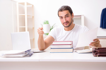 Young male student preparing for exams at home