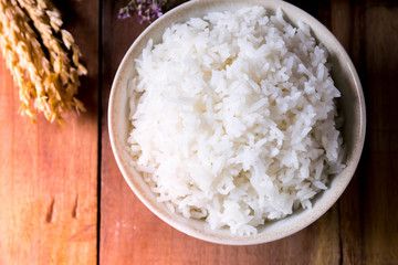 Soft focus, the picture on the top of the cup of white rice is delicious Laid on the old wooden floor