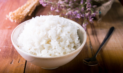 Soft focus. The picture on the front of the cup of white rice, laid on a delicious old wooden floor.