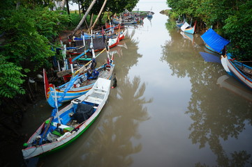 Obraz premium Traditional fishing vessels that still use traditional fishing gear, this boat is made of wood that is resistant to sea water. Fishing boats dock at the seashore.