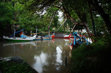 Obraz premium Traditional fishing vessels that still use traditional fishing gear, this boat is made of wood that is resistant to sea water. Fishing boats dock at the seashore.