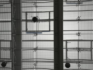 Ceiling of industrial building with metal girders and grid structures. Abstract black and white background photo on the subject of modern architecture, industry or business.