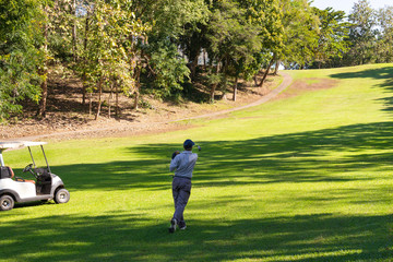 Obraz premium Man playing golf on a golf course.