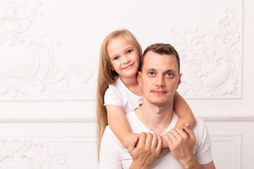 Little blond girl hugs her father and smile at father's day