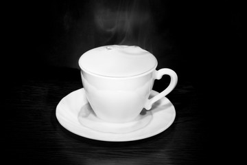 black coffee poured from a white mug on a dark background