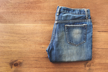 Blue jeans folded on white wooden background