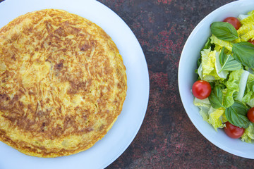 Traditional Spanish potatoes tortilla omelette with salad on a rusty table delicious food tapa tapas eat eating 