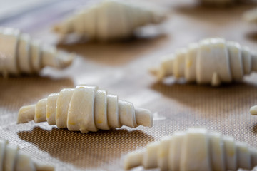 Fototapeta na wymiar Close up raw croissants preparation for with raw egg painted on top process before baking /baking concept / copy space