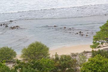 the atmosphere of the beach or the coast before the afternoon with calm waves and sunny weather set against the background of the high seas and mountains or plateaus