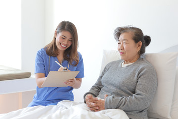 Asian Senior old woman on the bed with doctor and her son in hospital