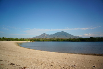 the atmosphere of the beach or the coast before the afternoon with calm waves and sunny weather set against the background of the high seas and mountains or plateaus