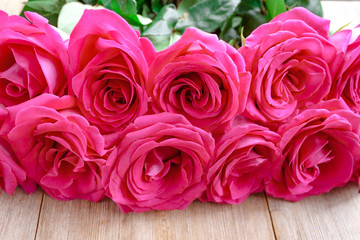 Obraz na płótnie Canvas Valentines day background with pink roses over wooden table. Top view with copy space