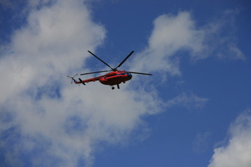 Flying helicopter against the blue sky