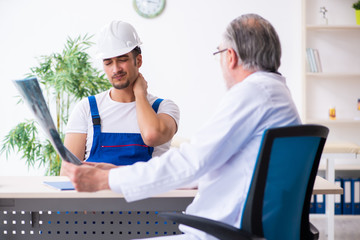 Young male contractor visiting old doctor