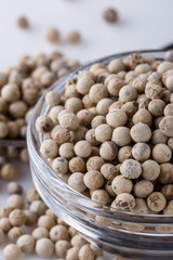 white peppercorns in glass bowl with spoon