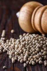 white peppercorns in wooden scoop on rustic background