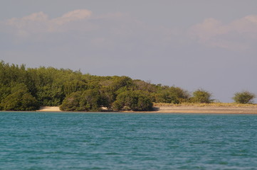 the atmosphere of the beach or the coast before the afternoon with calm waves and sunny weather set against the background of the high seas and mountains or plateaus