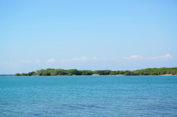 the atmosphere of the beach or the coast before the afternoon with calm waves and sunny weather set against the background of the high seas and mountains or plateaus