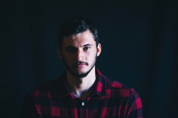 Young Handsome Man in Plaid Shirt on Dark Background