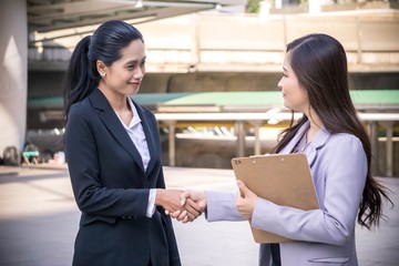 Happy smiling businesswomen shaking hands standing out of office. nice to meet you, first impression, congrats, promoted to the post, reward accomplishments.