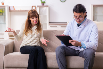 Young female patient discussing with male psychologist personal
