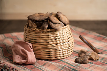fresh wild mushrooms, collected in a basket, on a table with checkered tablecloth