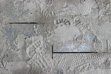 Footprints and markings on sand covered new pavement tiles