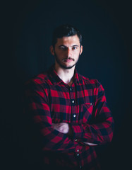 Young Handsome Man in Plaid Shirt on Dark Background