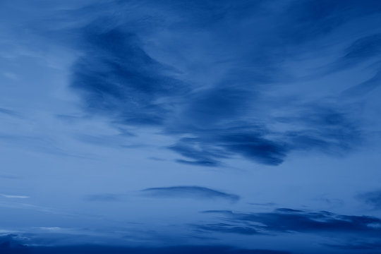 Dark classic royal blue clouds in night evening sky. Natural eco nature background texture with copyspace. Toned with trend popular color of 2020 year blue.