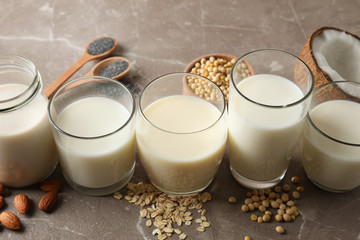 Glasses with different types milk on brown background, space foe text. Closeup