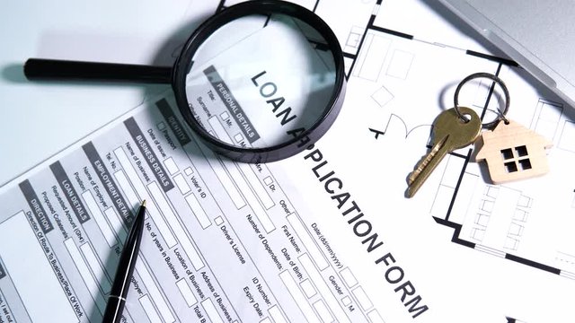 Loan application form and keys lying on table, search for favorable conditions