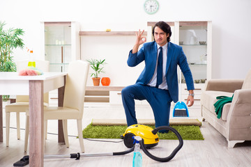 Young businessman cleaning the house