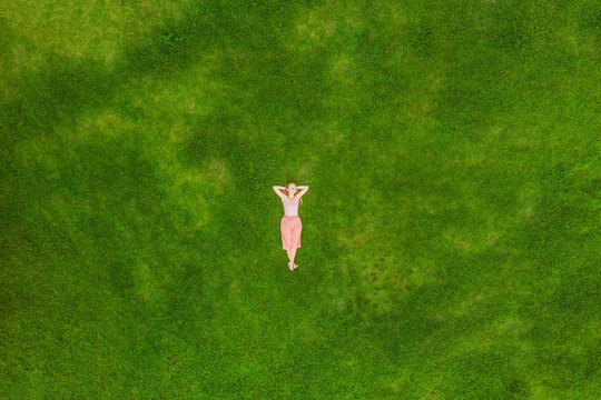 Young Woman Lying Down In The Middle Of A Field And Relaxing, Drone Photo