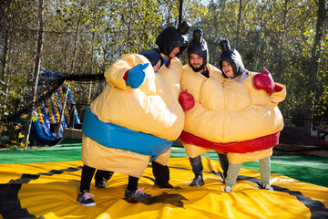 Friends posing in inflatable sumo suits