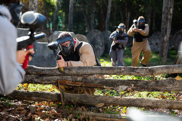Paintball players aiming outdoors