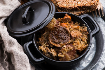 Traditional polish sauerkraut (bigos) with mushrooms and plums for christmas