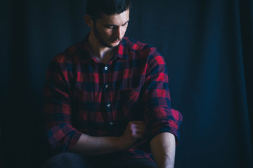 Young Handsome Man in Plaid Shirt on Dark Background