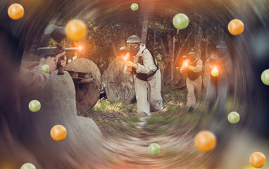 Paintball players shooting with guns