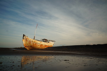Fototapeta premium Traditional fishing vessels that still use traditional fishing gear, this boat is made of wood that is resistant to sea water. Fishing boats dock at the seashore.