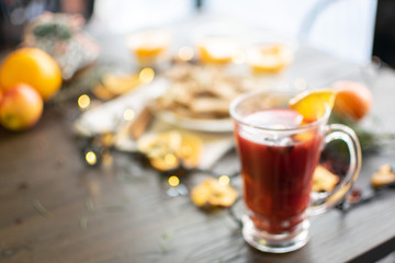 Mulled wine with christmas decorations and sweets close up blurred background