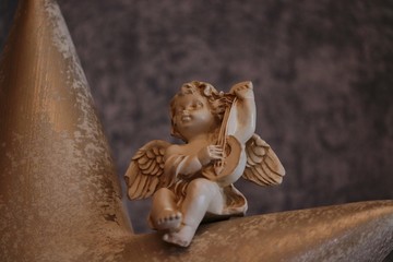 Figur Engel sitzt und musiziert
