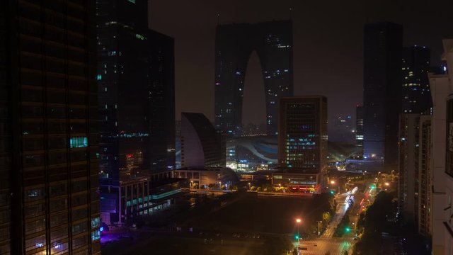 Timelapse Soochow automobiles heavy traffic on highway against modern buildings poorly illuminated in southeastern Jiangsu Province of East China at night