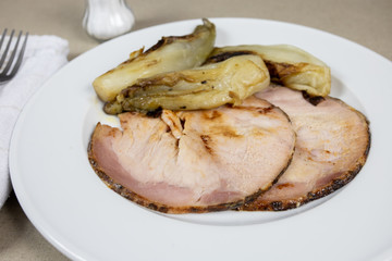 roast pork and braised endives on a plate