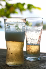 Glass of beer at bar table by the beach in summer