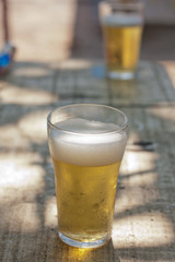 Glass of beer at bar table by the beach in summer